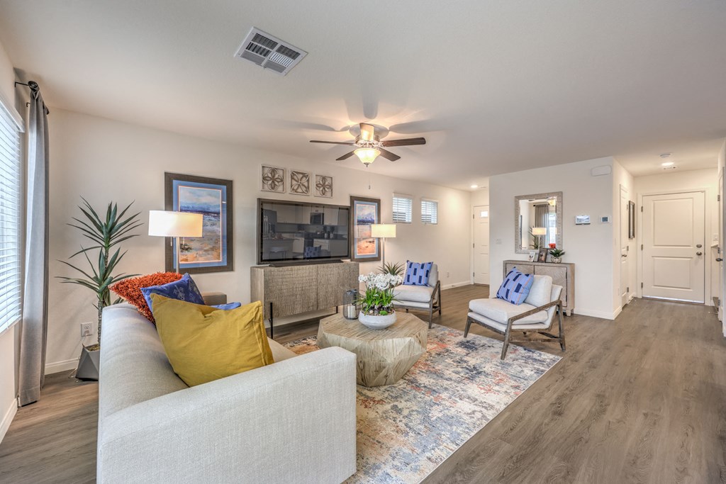 Homes for Rent in Mountain's Edge, NV - Shadow Bay - Spacious Living Room with Stylish Interior, a Ceiling Fan, and Vinyl Plank Flooring.