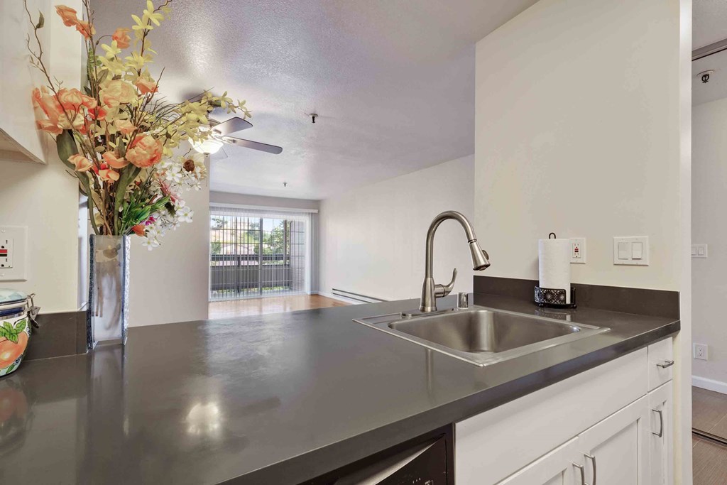 a kitchen with a sink and a vase of flowers