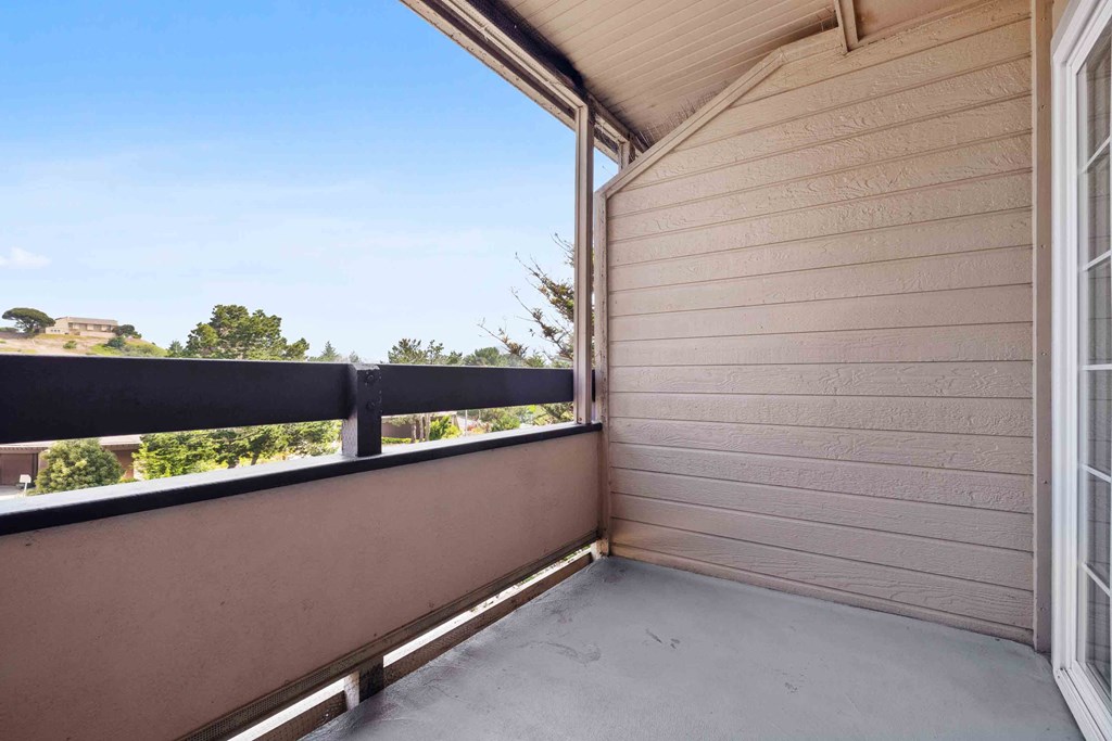 Two-Bedroom Apartments in Daly City, CA - Serra Commons - Patio with Sliding Door, Concrete Floor, and Neighborhood Views