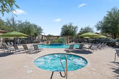 A pool with a ladder and chairs around it.