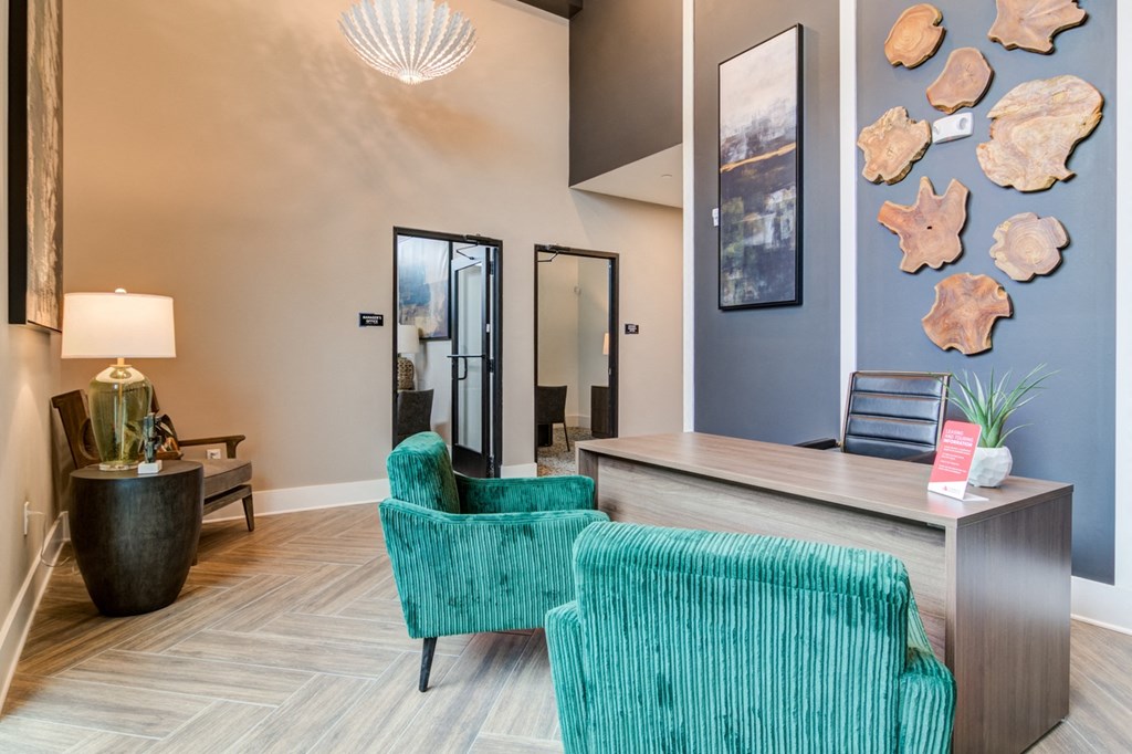 Sky Harbor Apartments in Chamblee, GA photo of a a living room with blue chairs and a desk and a wall with seashells
