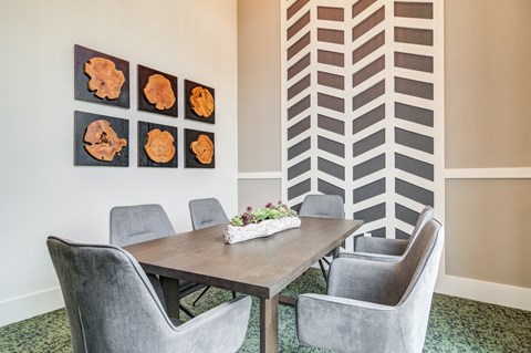a dining room with a table and chairs and artwork on the wall