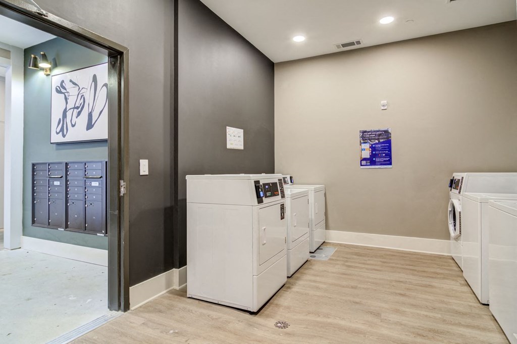 Sky Harbor Apartments in Chamblee, GA photo of a a laundry room with washers and dryers and a door to a closet