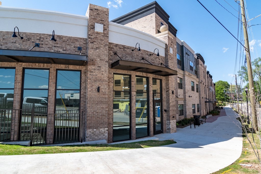 Sky Harbor Apartments in Chamblee, GA photo of a a brick building with large glass windows and a sidewalk