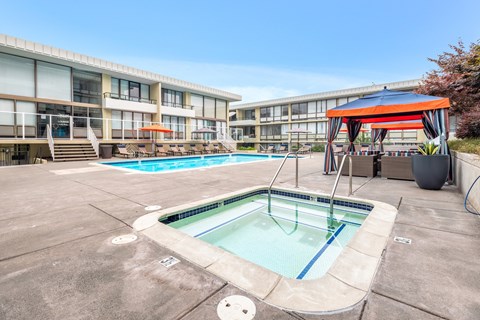 a pool and cabanas at an apartment building with a swimming pool