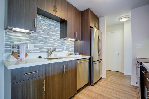 A kitchen with wooden cabinets and a stone backsplash.