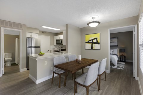 A kitchen with a dining table and chairs.
