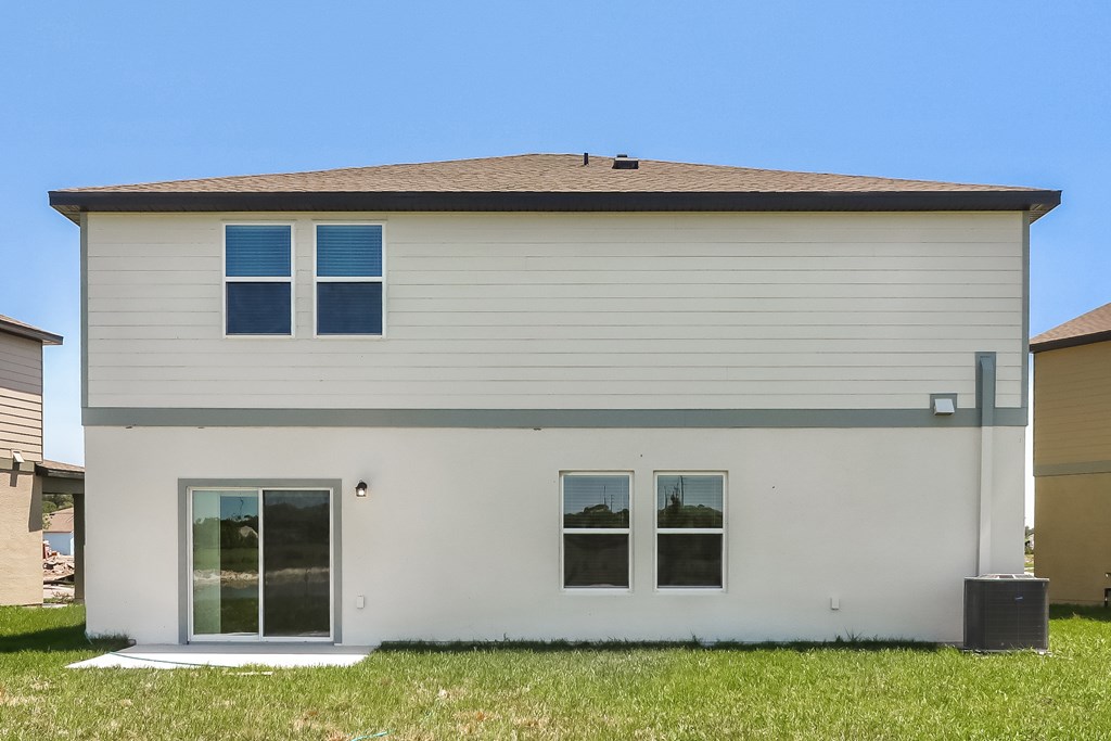A small house with a grey roof and white walls.