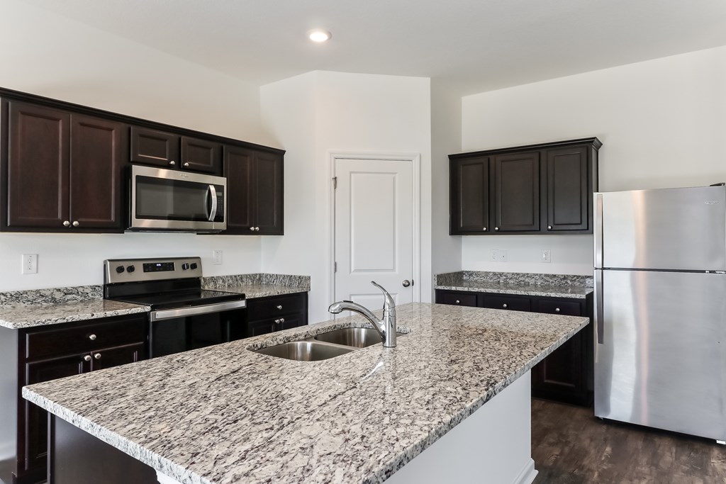 A kitchen with granite countertops and stainless steel appliances.
