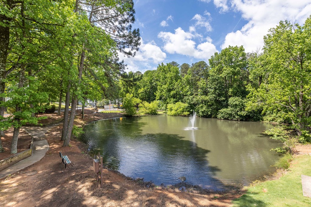 Lake with a fountain and seating area to enjoy the view at Somerset Apartments, a pet-friendly community in Charlotte near Huntersville, NC.