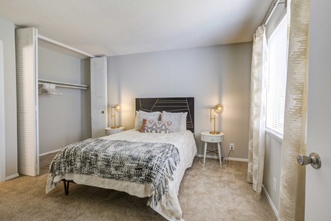 a bedroom with a bed and two windows