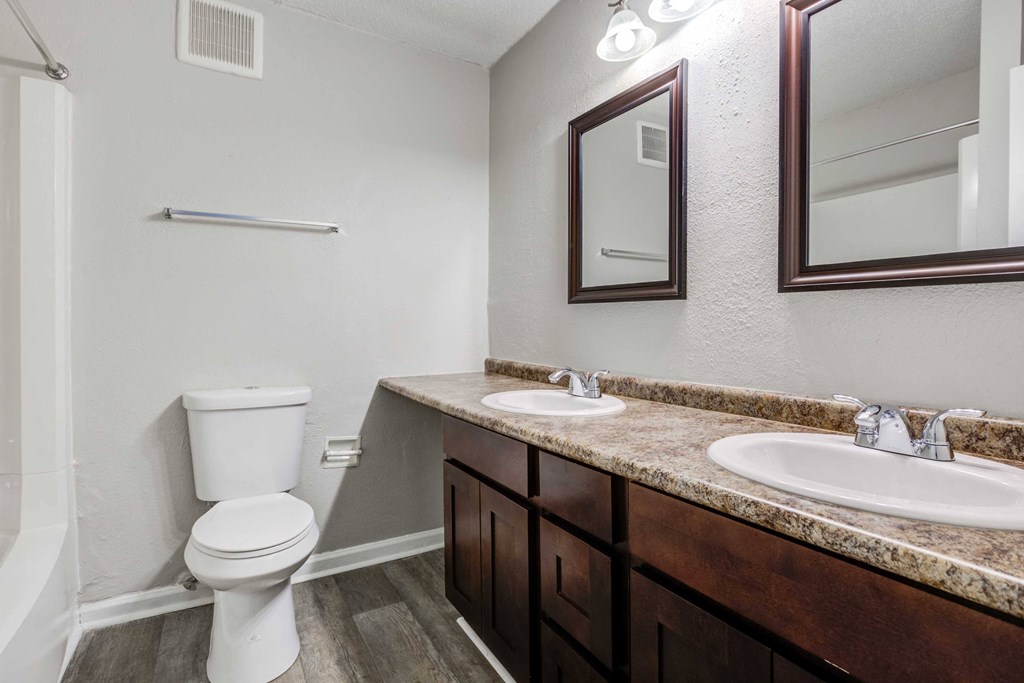 Bathroom at Somerset Apartments near Charlotte and Huntersville, NC, featuring a double vanity with two mirrors.