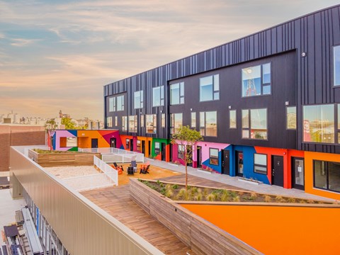 A modern building with colorful exterior walls and a wooden deck in front.