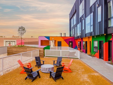 A colorful building with a patio and chairs.