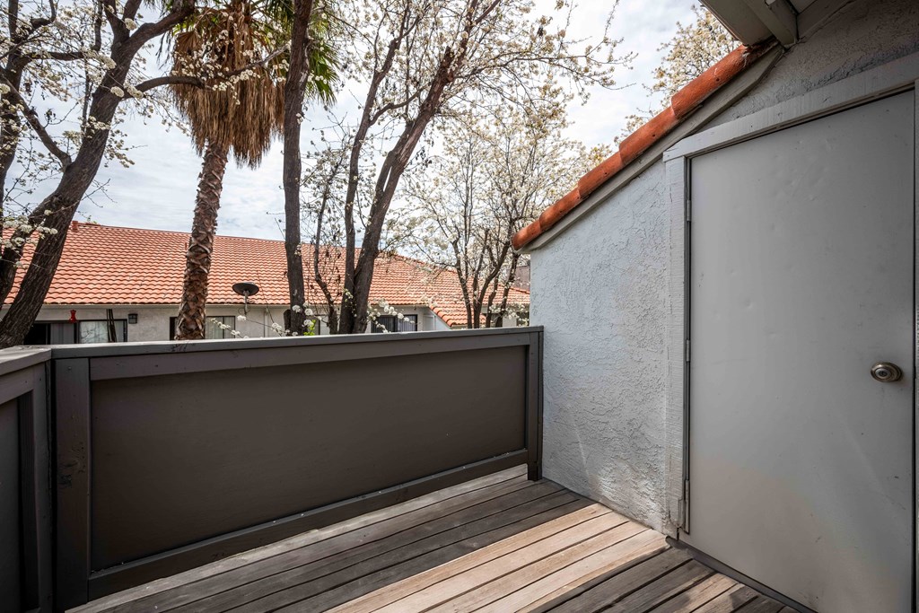 a balcony with a view of trees and a house