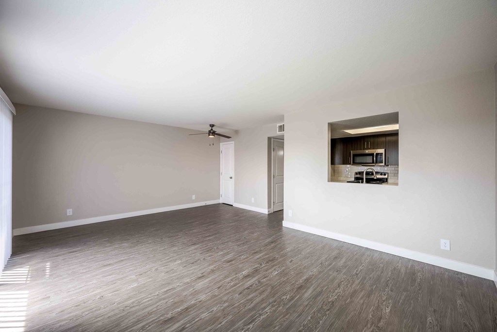 an empty living room with white walls and wood floors
