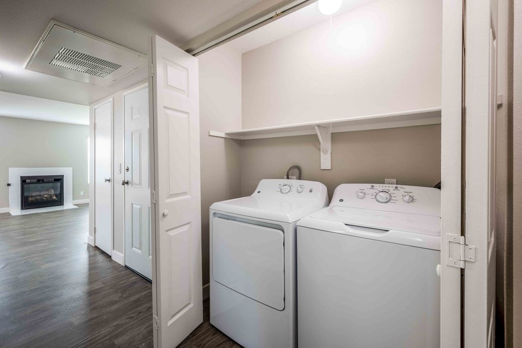 Pet-Friendly Apartments In Moreno Valley, CA - Sorelle Apartments - Laundry Closet with In-Home Washer and Dryer, Storage Shelf, and Folding Door.