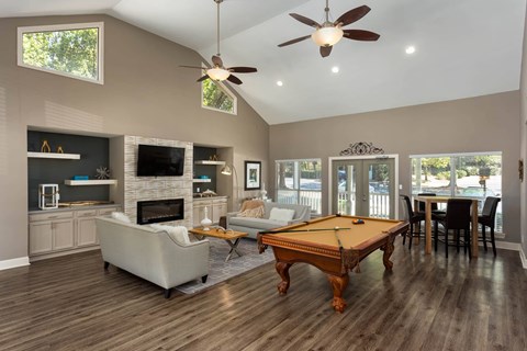 A spacious living room with a pool table and a fireplace.