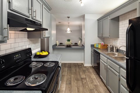 A modern kitchen with a black stove top oven.