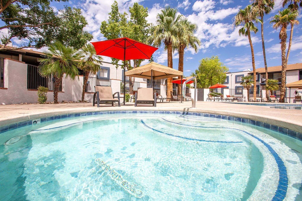 Pet-Friendly Apartments in Tucson, AZ - Peaks at Redington - Soothing Spa Surrounded By Lounge Chairs, Umbrellas, Palm Trees Next to the Swimming Pool