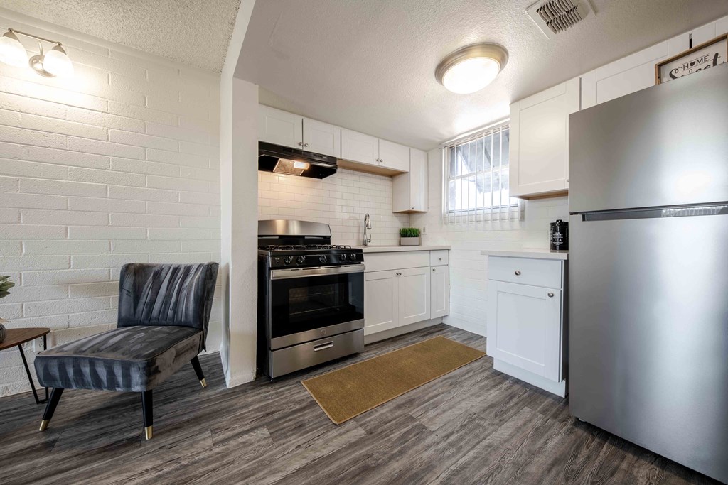 a kitchen with stainless steel appliances and a chair
