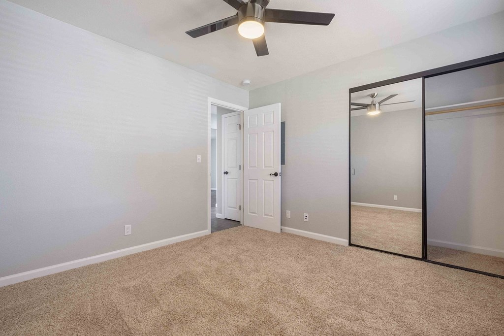 Apartments Milpitas - Spring Valley - Spacious Bedroom With High Ceilings, Ceiling Fan, Carpet Flooring, And Large Closet With Mirrors