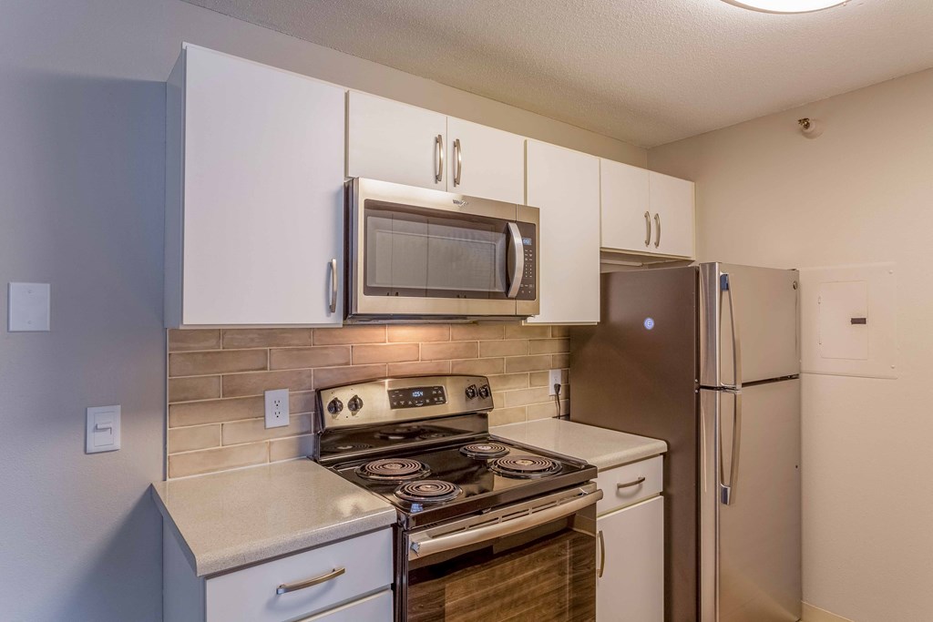 a kitchen with stainless steel appliances and white cabinets