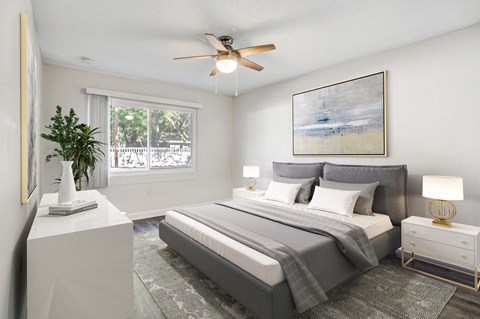 Bedroom with large window, natural light, and ceiling fan at Square One Apartments in Gainesville FL