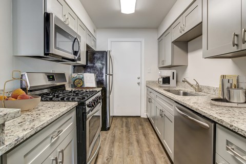a kitchen with white cabinets and stainless steel appliances and granite counter tops