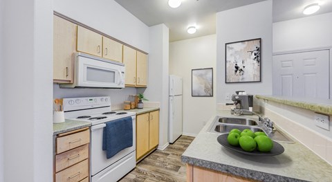 A kitchen with a white stove and a microwave above it.