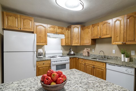 Kitchen at Stratford Ridge Apartments in Marietta, GA, showcasing warm wooden cabinets and clean white appliances, offering a bright and functional cooking space.