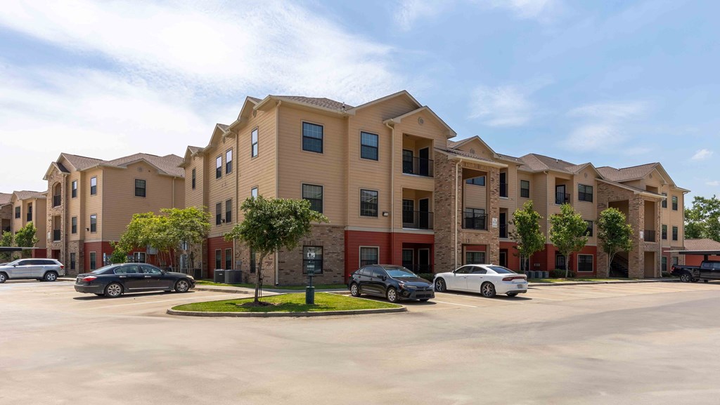 Sugar Mill Apartments in Addis, LA photo of a large apartment building with cars parked in front of it