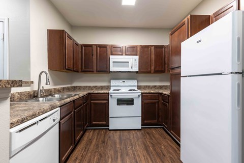 a kitchen with white appliances and wooden cabinets