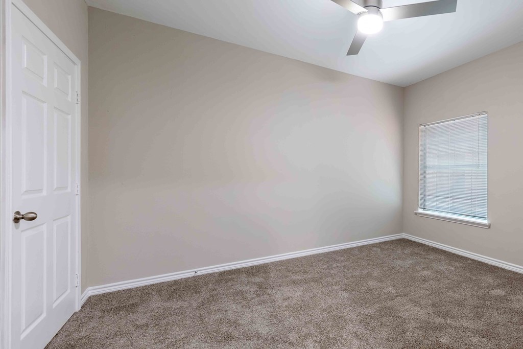 Sugar Mill Apartments in Addis, LA photo of an empty bedroom with a white door and a window