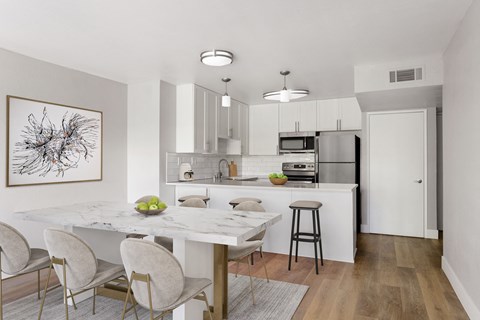 A modern kitchen with a dining table and chairs.