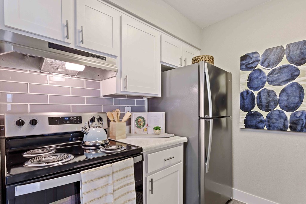 a kitchen with stainless steel appliances and white cabinets