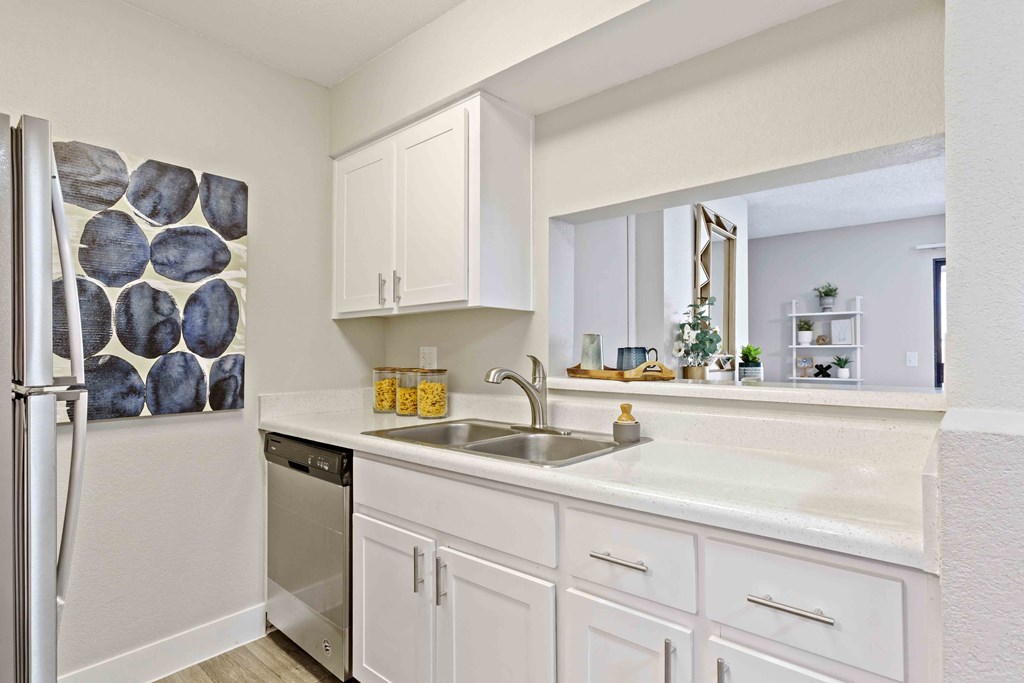 a kitchen with white cabinets and a stainless steel refrigerator