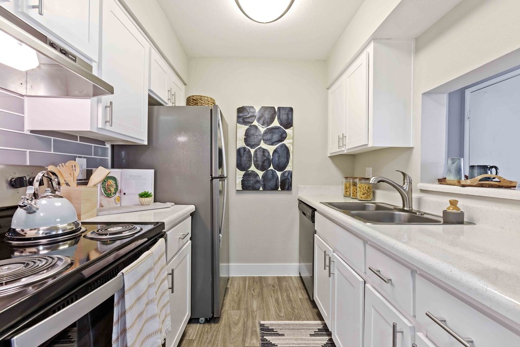 a kitchen with white cabinets and a stainless steel refrigerator