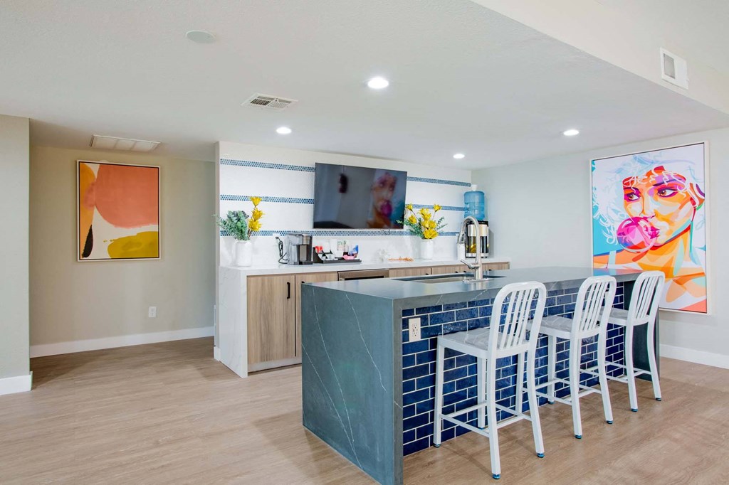 a kitchen with a blue counter and chairs