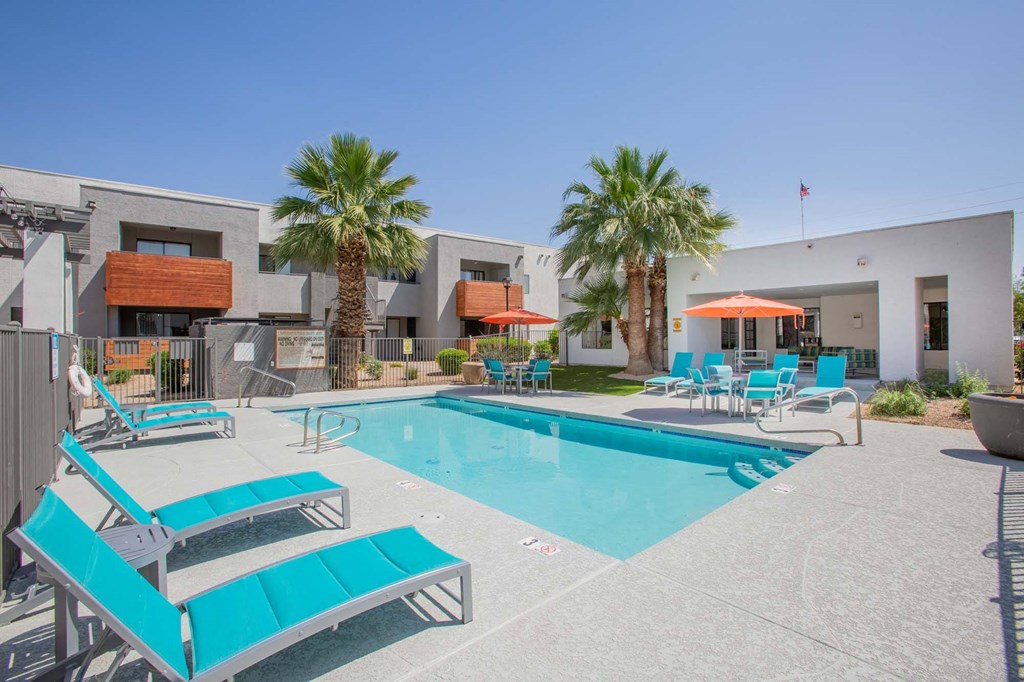 our apartments have a large swimming pool with chairs and umbrellas