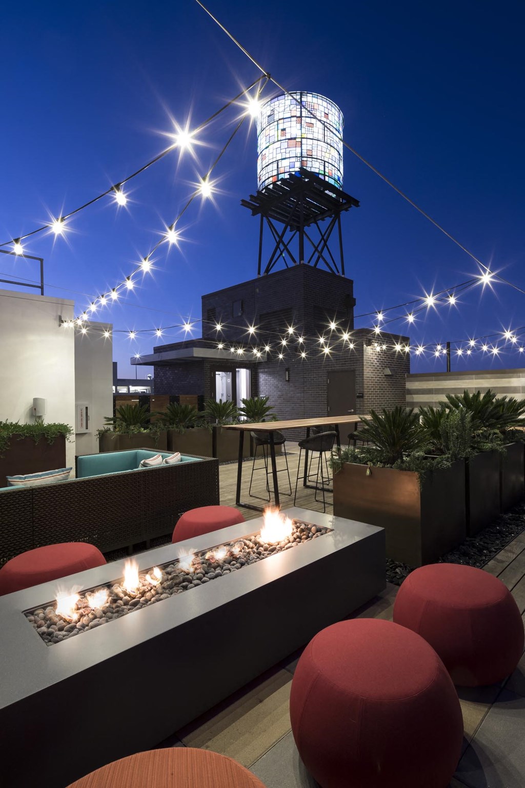 a rooftop bar with a water tower at night