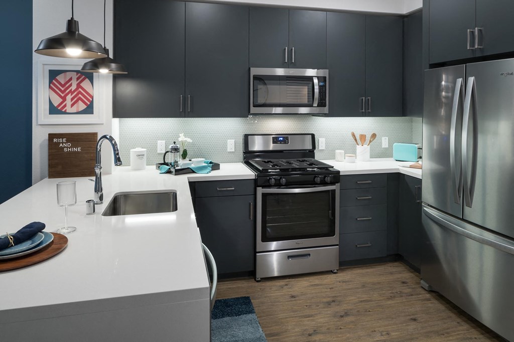 a kitchen with stainless steel appliances and a white counter top