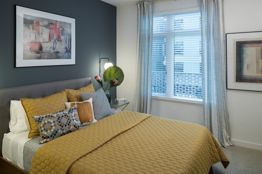 a bedroom with a yellow bed and a window