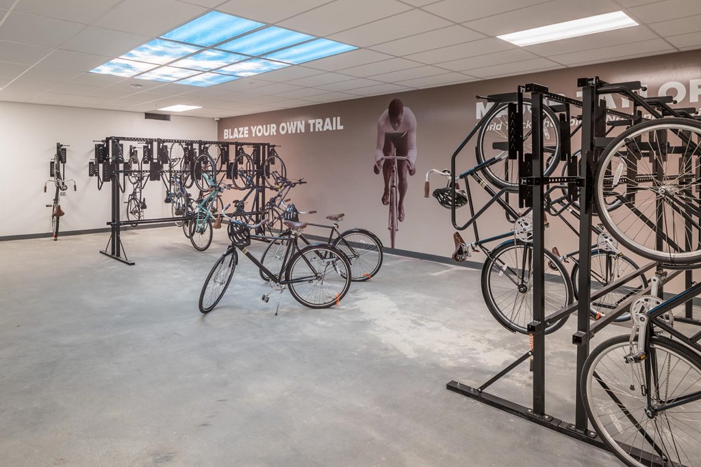 a group of bikes on display in a room with a bike rack