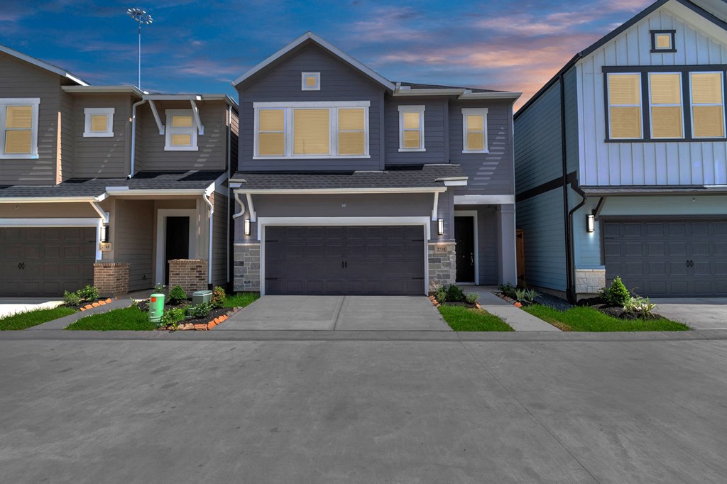 a house with a long driveway and a blue sky in the background
