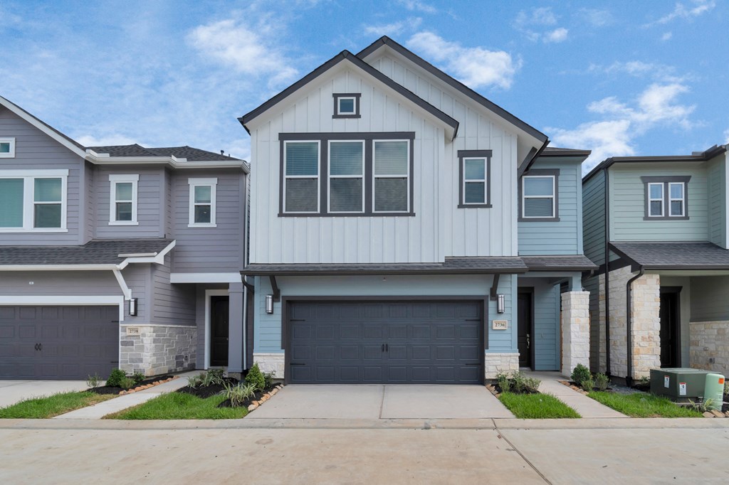 Heights, Houston TX Houses for Rent - The Crossing at Timbergrove - Home Exterior with Grey and White Walls, a Garage, Front Drive, and Landscaped Plant Beds, From Street View