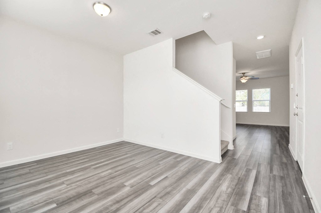 A room with a wooden floor and a staircase.