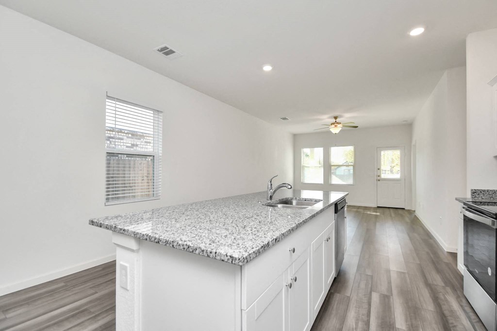 A kitchen with a granite countertop and white cabinets.