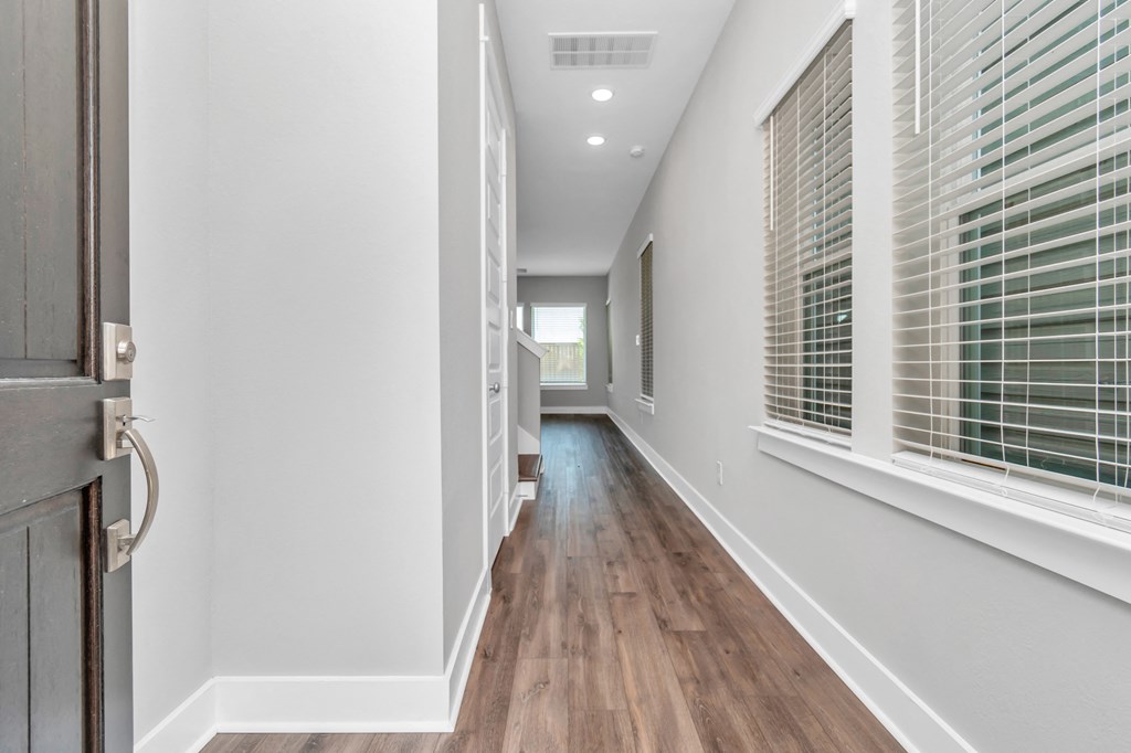 a hallway with hardwood floors and grey walls