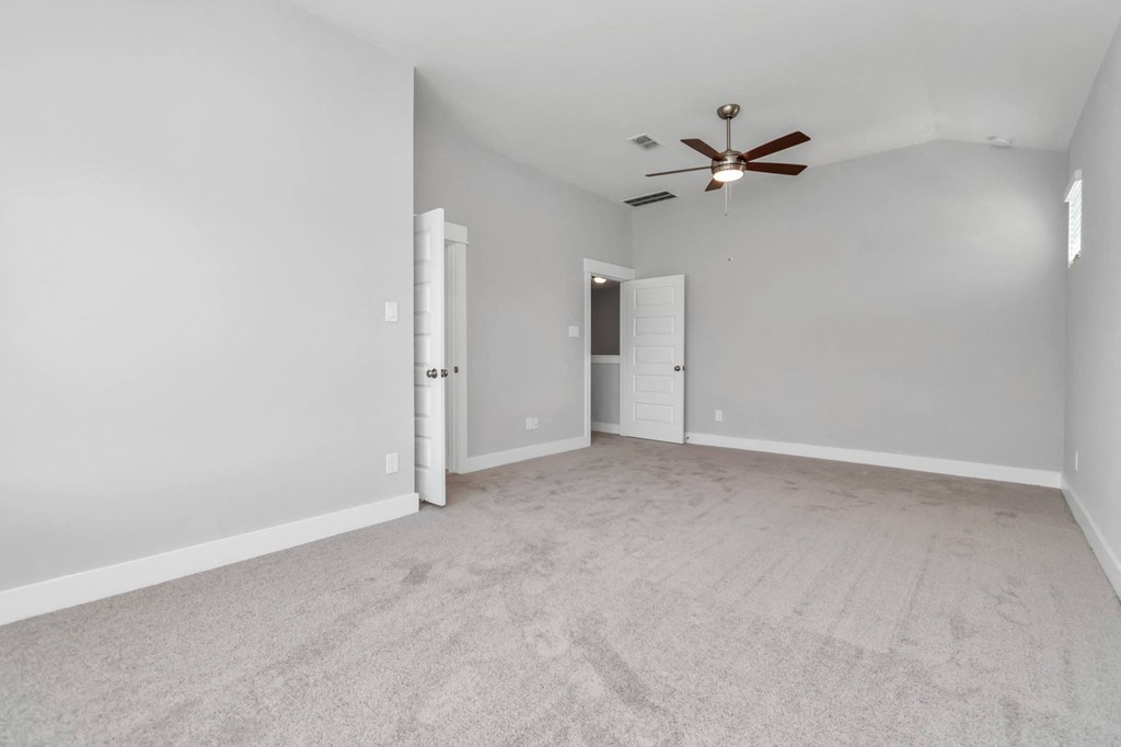 3 Bedroom Homes for Rent in Heights, Houston TX - The Crossing at Timbergrove - Carpeted, Unfurnished Bedroom with Soft Grey Walls, a Closet, and a Ceiling Fan